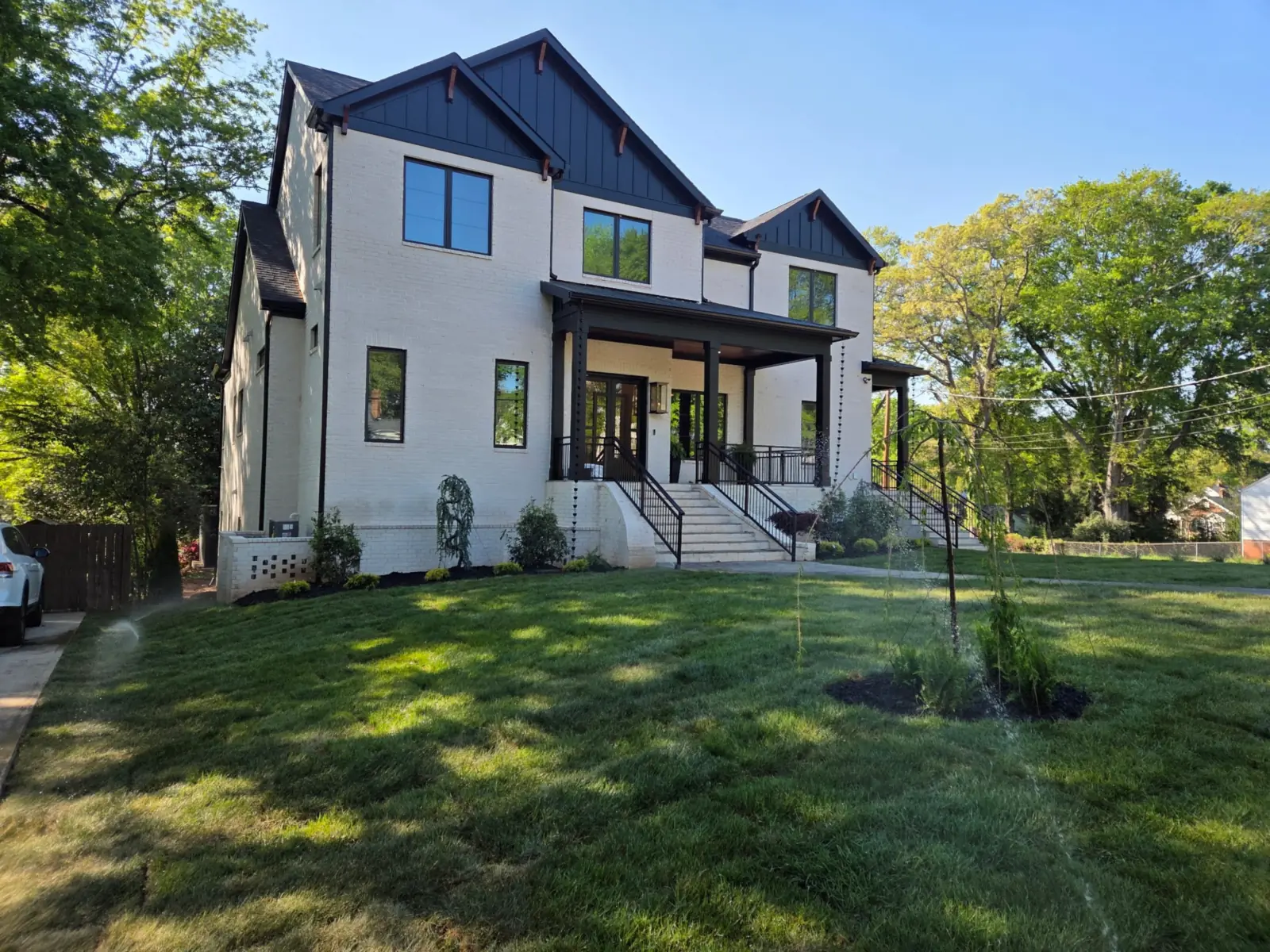 New lawn with an irrigation head running in front of a two-story home